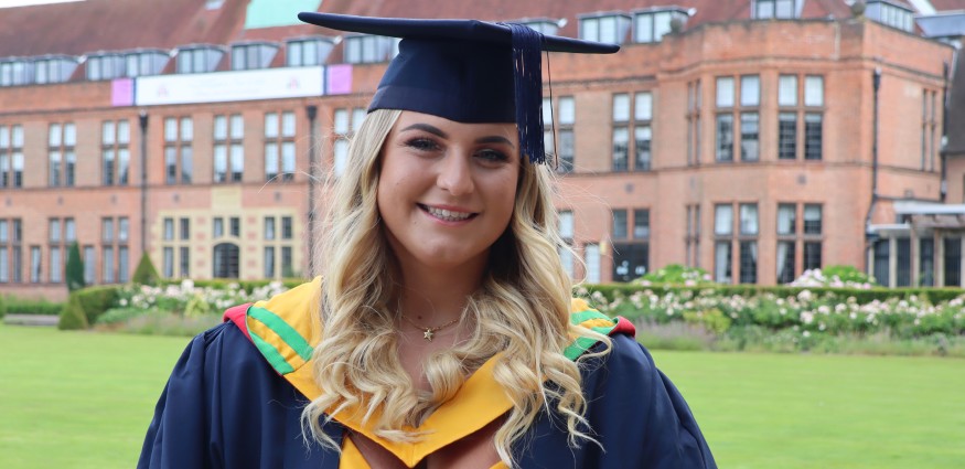 A female student wearing a graduation cap and gown.